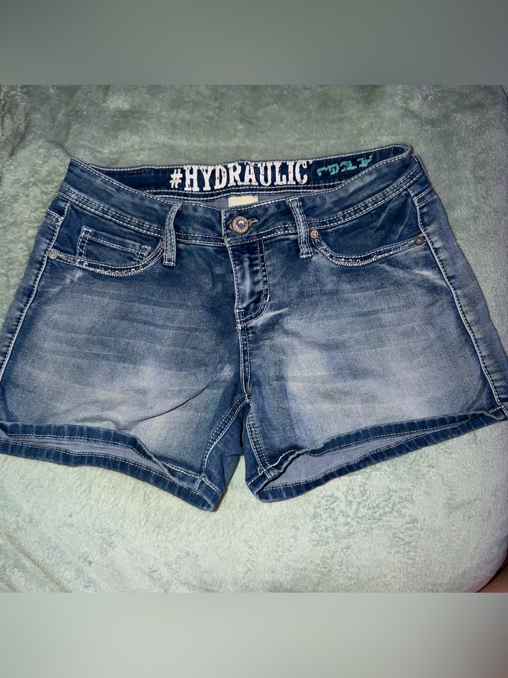 Hydraulic blue denim shorts with white embroidered pocket designs